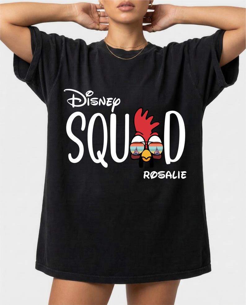 May include: Black t-shirt with the text "Disney SQUAD" in white, featuring a cartoon chicken wearing sunglasses. The name "ROSALIE" is printed below the chicken graphic.