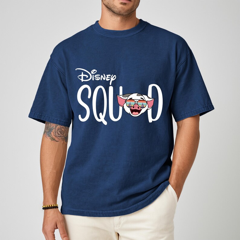 May include: Navy blue t-shirt with the text "Disney Squad" in white. The letter "D" is replaced with a cartoon pig wearing sunglasses. The shirt is made of a soft material.