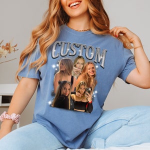 May include: A light blue t-shirt with the word "CUSTOM" in a silver, retro font. The shirt features a collage of photos of a person, with sparkling star accents.