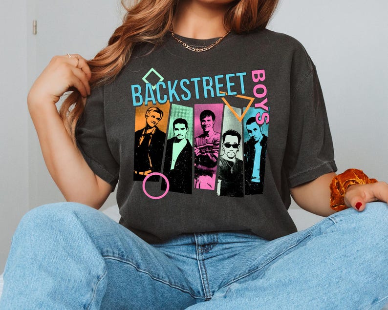 May include: Dark gray t-shirt featuring the text "BACKSTREET BOYS" in a colorful, retro design. The graphic includes images of the band members in individual panels. The shirt is a vintage style.