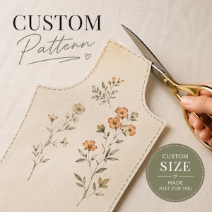 Peut inclure: Un motif personnalisé avec des illustrations florales orange et blanches, coupé avec des ciseaux dorés. Les textes "CUSTOM Pattern" et "CUSTOM SIZE" sont visibles.