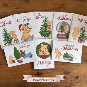 May include: A collection of eight Christmas and holiday greeting cards featuring Winnie the Pooh characters. Each card has a different design, including images of Pooh with Christmas trees, gifts, and snow globes. The words "Merry Christmas", "Happy Holidays", and "a gift Just for you" are printed on the cards.