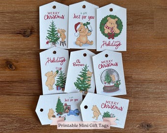 May include: A collection of white gift tags with various Christmas-themed illustrations. The tags feature images of a bear, Christmas trees, and snow globes, with phrases like "Merry Christmas" and "Happy Holidays".