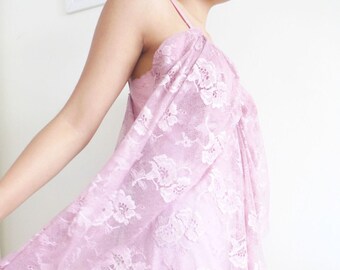May include: A pale pink lace slip dress with a scalloped hem. The dress is layered with a sheer lace overlay.