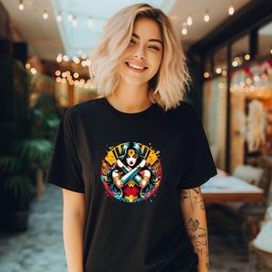 May include: Black t-shirt with a colorful graphic of Wonder Woman with her arms crossed. The graphic is surrounded by a yellow and orange splattered paint effect.