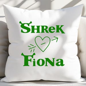 Pu&ograve; includere: Cuscino bianco con testo verde che dice "Shrek" con una freccia che punta a un cuore verde che dice "Fiona".