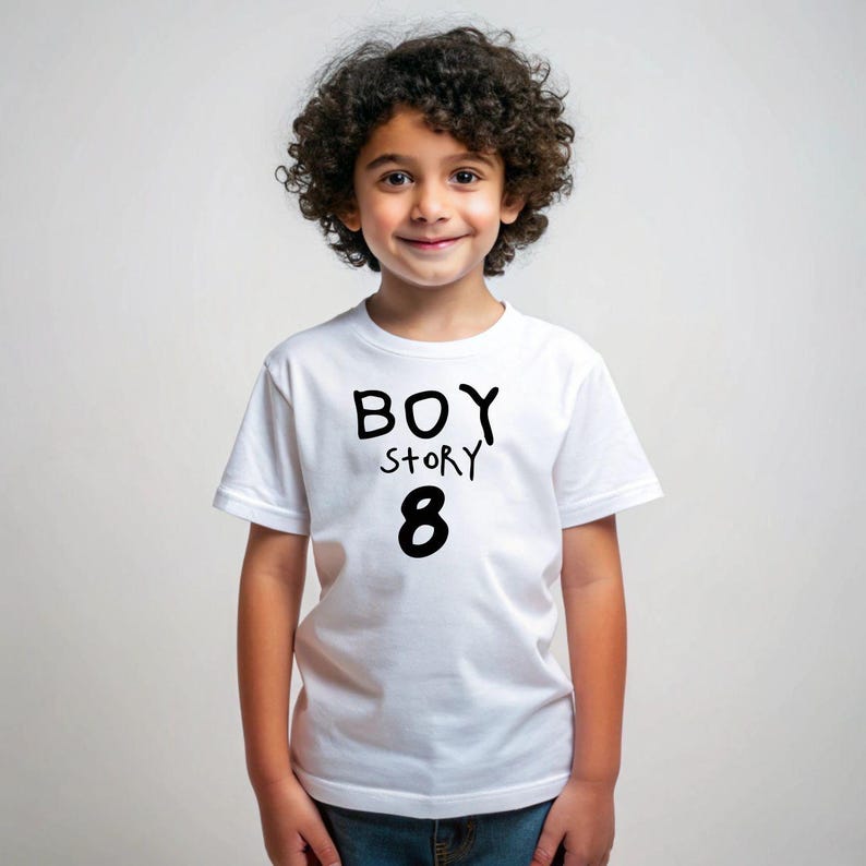 K&ouml;nnte beinhalten: Wei&szlig;es T-Shirt mit schwarzem Text, auf dem "BOY STORY 8" steht. Ein Kind tr&auml;gt das Shirt.