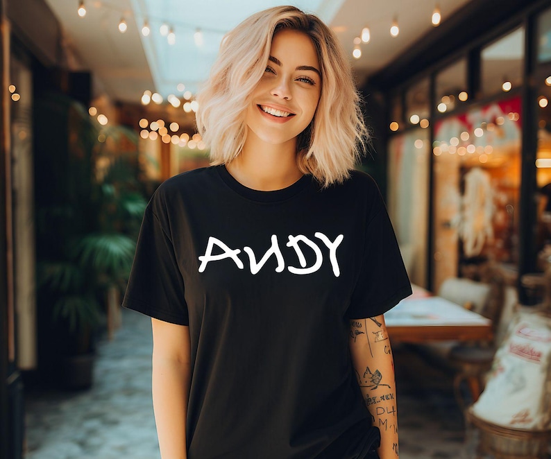 K&ouml;nnte beinhalten: Ein schwarzes T-Shirt mit dem Wort "ANDY" in wei&szlig; auf der Vorderseite.