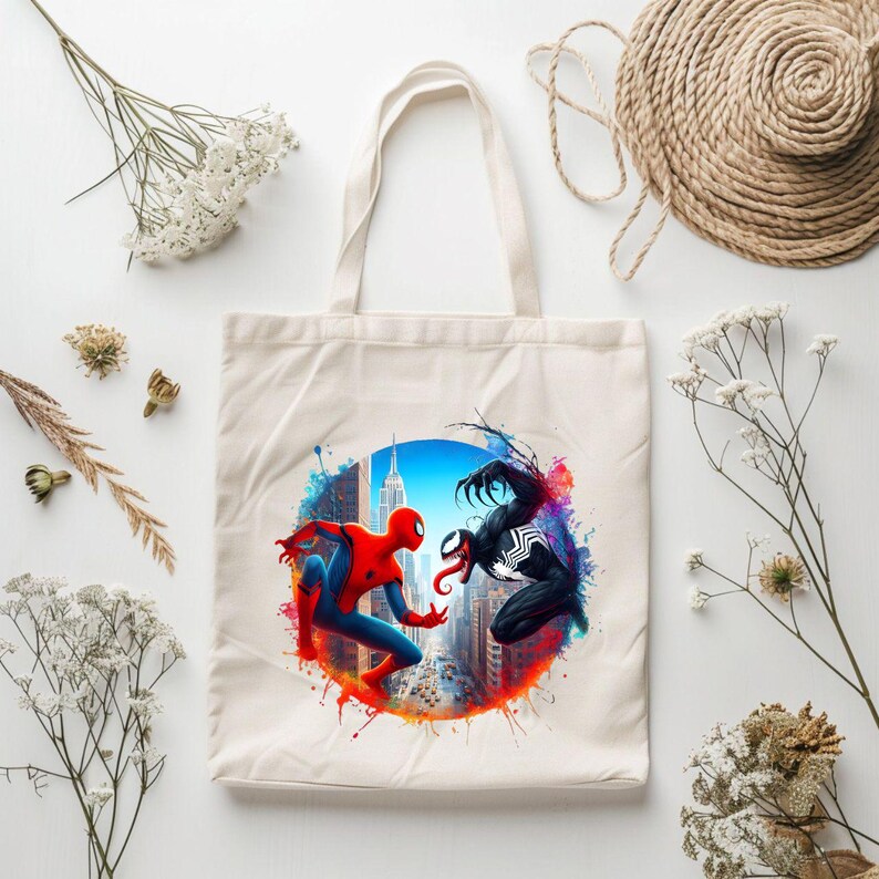 May include: A white canvas tote bag featuring a colourful graphic of Spider-Man and Venom facing each other in a New York City cityscape. The graphic is surrounded by a circle of colourful paint splatters.