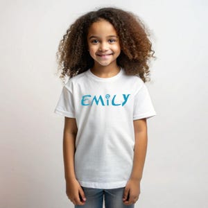 May include: White t-shirt with a blue and teal "EMILY" graphic on the front.
