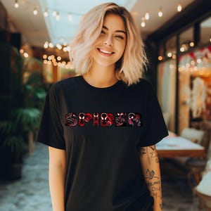 Może przedstawiać: Czarny T-shirt z czerwono-czarną grafiką słowa "SPIDER" złożonego z wielu twarzy Spider-Mana.