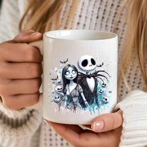 Może przedstawiać: Biały kubek ceramiczny z akwarelowym wzorem Jacka Skellingtona i Sally z filmu Koszmar przed świętami. Wz&oacute;r zawiera niebieskie i białe plamy akwarelowe oraz czaszki.