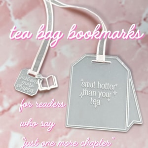 Op de afbeelding: Een theezakje-vormige boekenlegger met een wit lint bevestigd aan een kleiner label met de tekst "just one more chapter" en een boekicoon. Het hoofdlabel is doorschijnend grijs met de witte tekst "smut hotter than your tea" en steraccenten.