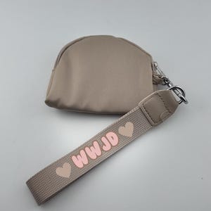 Bolso de mano con una sola bolsa en color rosa/neutro con la frase ¿Qué haría Jesús?