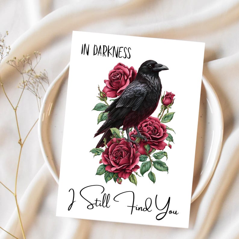 May include: A white card featuring a black raven illustration amidst red roses and green foliage. The text "IN DARKNESS" is at the top, with "I Still Find You" in script at the bottom.