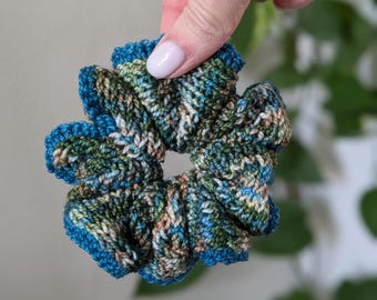 May include: A blue, green, and white crocheted hair scrunchie.