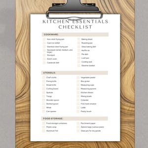 May include: A kitchen essentials checklist on a wooden clipboard. The checklist includes cookware, utensils, and food storage items. The text is in a clean, easy-to-read font, perfect for organizing a kitchen.