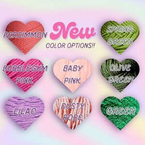 May include: Image showcasing nine heart-shaped yarn samples in various colors, including persimmon, bubblegum pink, baby pink, lilac, dusty rose, spring green, olive green, and green. The word "New" is displayed in pink script, with "COLOR OPTIONS!!" below.