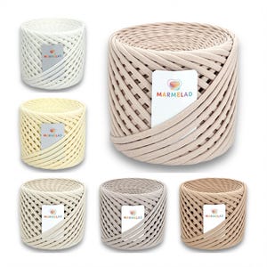 May include: Six spools of cotton rope yarn in various colors, including beige, cream, light brown, and gray. Each spool has a label with the word "MARMELAD" printed on it.