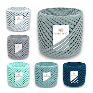 May include: Six spools of colourful yarn in various shades of blue and green. Each spool is labelled with the word "MARMELAD" in a white rectangle with a red heart.