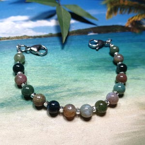 May include: A bracelet made of green, brown, and pink agate beads with silver clasps.