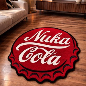 May include: A circular red rug with a black, scalloped border, designed to look like a bottle cap. The rug displays the white text "Nuka Cola" in a distinctive font. A decorative item suitable for a living room or games room.