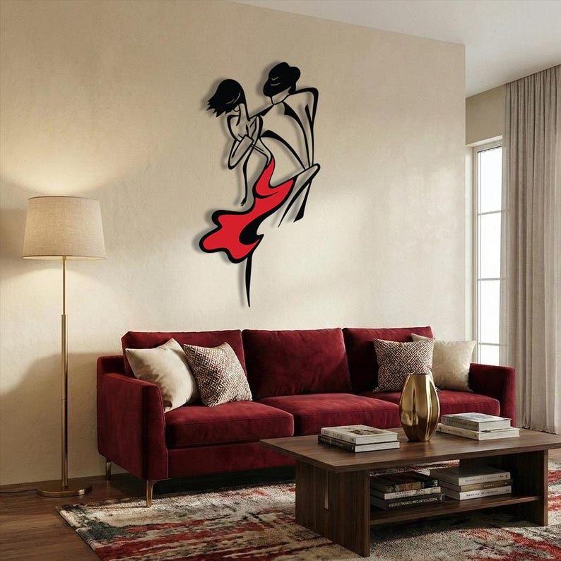 May include: A black and red metal wall art piece depicting a stylized silhouette of two figures dancing. The design features clean, minimalist lines with the female figure wearing a flowing red dress and the male figure in a black hat and suit.