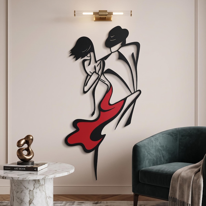 May include: A black metal wall art piece depicting a stylized couple dancing, featuring a figure in a hat and a figure in a flowing dress with a prominent red section. The design uses bold, continuous lines to create a fluid, abstract silhouette.