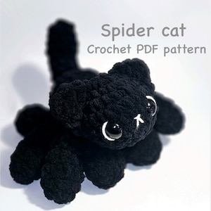 Op de afbeelding: Zwart gehaakt spinnenkat amigurumi speelgoed met witte ogen. Haakpatroon PDF.
