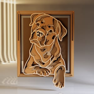 May include: A layered wooden artwork of a dog in a framed rectangular shape. The dog is depicted in shades of brown and tan, with a paw extended. The artwork is displayed against a brown background.