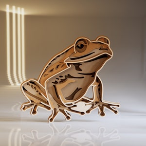 Puede incluir: Una escultura de rana de madera con un diseño en capas recortadas. La rana es marrón y está sentada sobre una superficie blanca con un reflejo de la rana visible.
