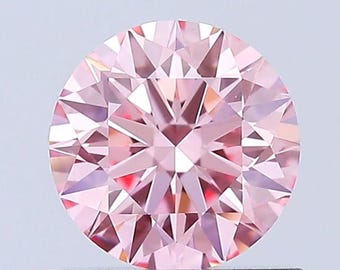 Puede incluir: Un diamante redondo rosa con un corte facetado. El diamante está engastado en un engaste blanco transparente.
