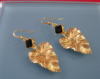 Les boucles d'oreilles feuille d'or.