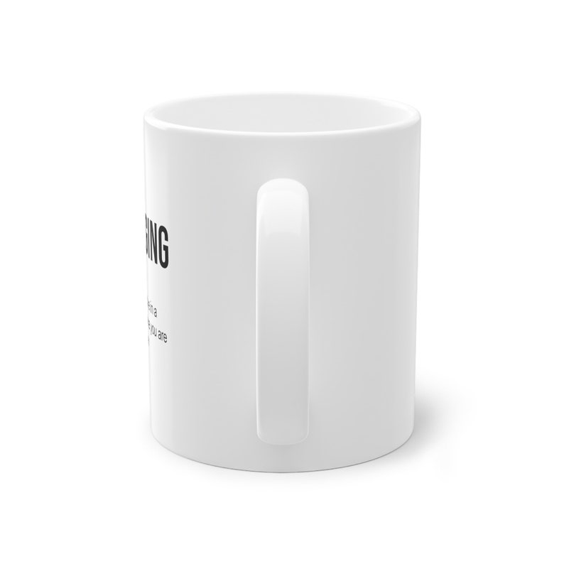 Puede incluir: Taza de cer&aacute;mica blanca con un gr&aacute;fico negro que dice "Hustling" y una definici&oacute;n de la palabra. La definici&oacute;n dice: "El acto de una persona que siempre est&aacute; en movimiento y trabaja duro para alcanzar sus objetivos."