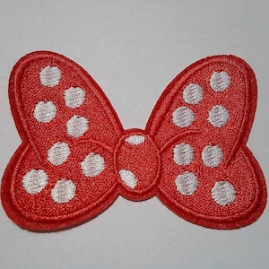 Könnte beinhalten: Roter Stoffbogen mit weißen Punkten. Der Bogen ist ein flaches Bügelbild.