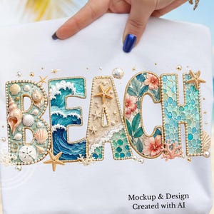 May include: A white t-shirt featuring the word BEACH in large letters. Each letter is decorated with coastal elements including seashells, starfish, coral, blue ocean waves, tropical hibiscus flowers, and sand textures, accented with small white pearls.