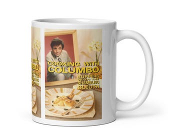 Peut inclure: Mug en céramique blanche avec une image encadrée. L'image présente le texte "COOKING WITH COLUMBO" et "SUPPERS WITH THE SHAMBLING SLEUTH." L'image montre un homme en costume et une assiette de nourriture. La tasse a une anse incurvée.