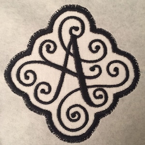 May include: Black embroidered iron-on patch with a stylized letter A surrounded by swirls.