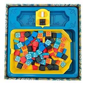 Peut inclure: Un plateau de jeu bleu et jaune avec un bac à tuiles rempli de tuiles colorées. Le bac est étiqueté "Azul" en lettres jaunes.