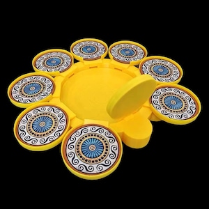 Puede incluir: Una bandeja circular amarilla con una tapa extraíble y ocho compartimentos circulares más pequeños. Cada compartimento tiene un diseño de patrón azul y dorado.