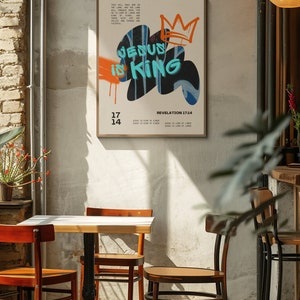 May include: A poster with a white background and a black, blue, and orange graphic of the words "Jesus is King" with a crown above the words. The poster also includes the text "Revelation 17:14" and the text "Jesus is King of Kings" repeated four times.