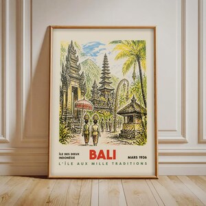 以下が含まれることがあります： インドネシア、バリ島のヴィンテージ旅行ポスター。木製のフレームに入っています。寺院複合施設、人物、ヤシの木が描かれています。ポスターには「Bali Mars 1936」の文字があります。ポスターはクリーム色の背景で、茶色のフレームです。