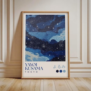 May include: A framed art print depicting a night sky with dark and light blue clouds and stars. The print includes the text "YAYOI KUSAMA TOKYO" and Japanese characters. The artwork is presented in a wooden frame.