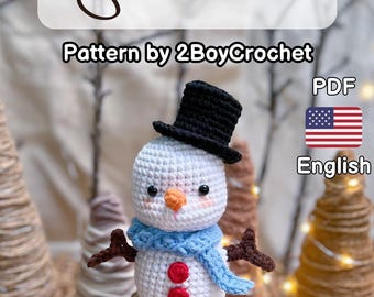 May include: Crochet pattern for a snowman amigurumi toy. The snowman is wearing a black top hat, a blue scarf, and has red buttons. The pattern is available in PDF format and is written in English.