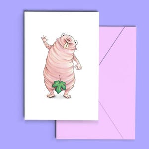 May include: A whimsical greeting card featuring a cartoon character with a pink, wrapped body, large teeth, and a green leaf covering its lower body. The character is waving. The card is on a white background with a pink envelope.