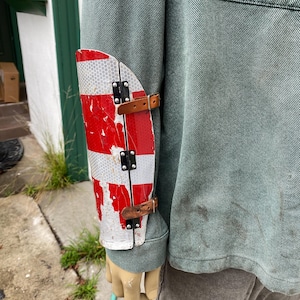 Hinged metal bracer made from traffic sign.