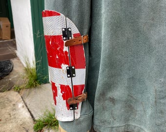 Hinged metal bracer made from traffic sign.