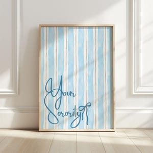May include: A framed print with a light blue and white striped pattern. The words "Your Sorority" are written in teal cursive script. The artwork is displayed on a wooden floor against a white wall.