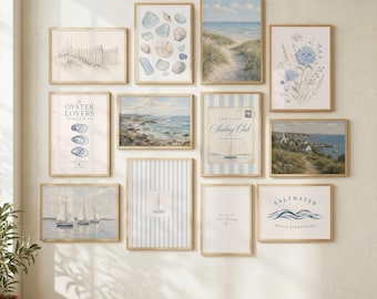 May include: A collection of framed coastal art prints in various sizes. The prints feature beach scenes, seashells, sailboats, and inspirational quotes in shades of blue, beige, and white. The frames are a light wood color, creating a cohesive gallery wall.