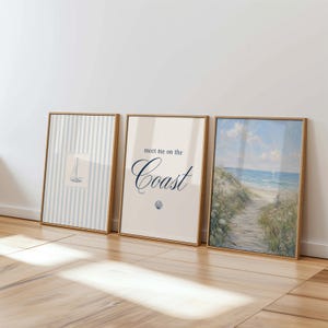 May include: Three framed coastal art prints. The first shows a sailboat on blue and white stripes. The second says "meet me on the Coast" with a seashell graphic. The third is a beach scene with a path to the sea.